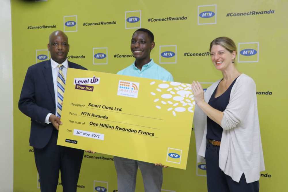 MTN Rwanda and Inkomoko handing over a dummy cheque to one of winners.  