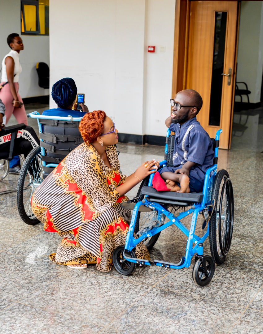 Gahongayire chatting with one of beneficiaries after the handover of wheelchairs on Friday.