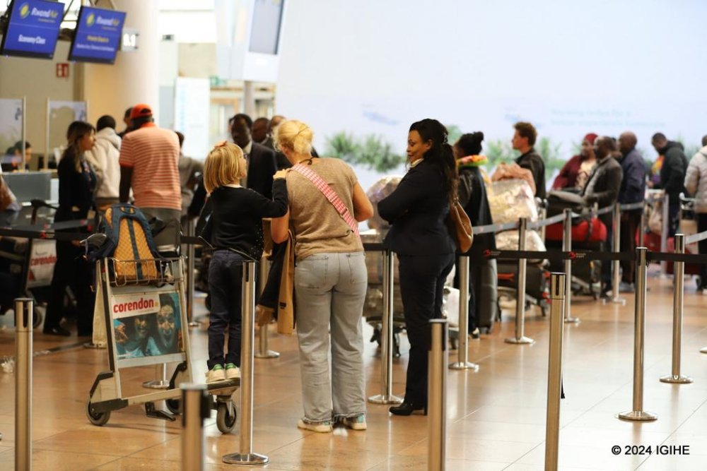 Passengers queue to complete their travel formalities before boarding the RwandAir flight.