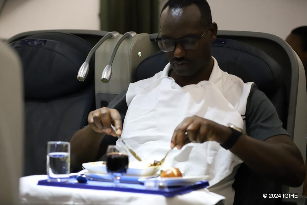 One of the RwandAir passengers enjoys his meal during the Paris-Kigali flight