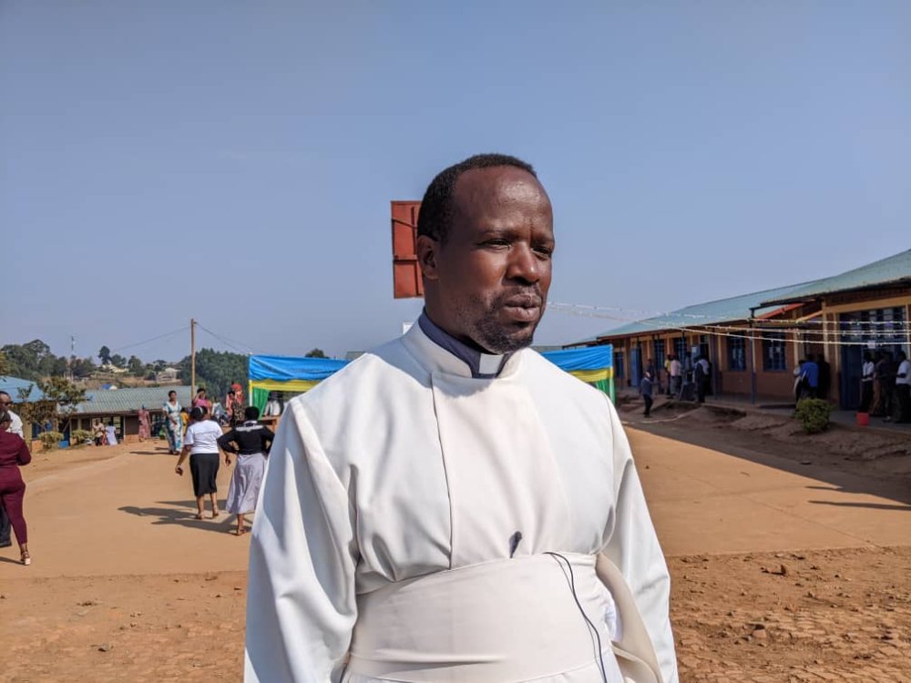 Father Vincent Nsengiyuma speaks to the media after casting his vote.