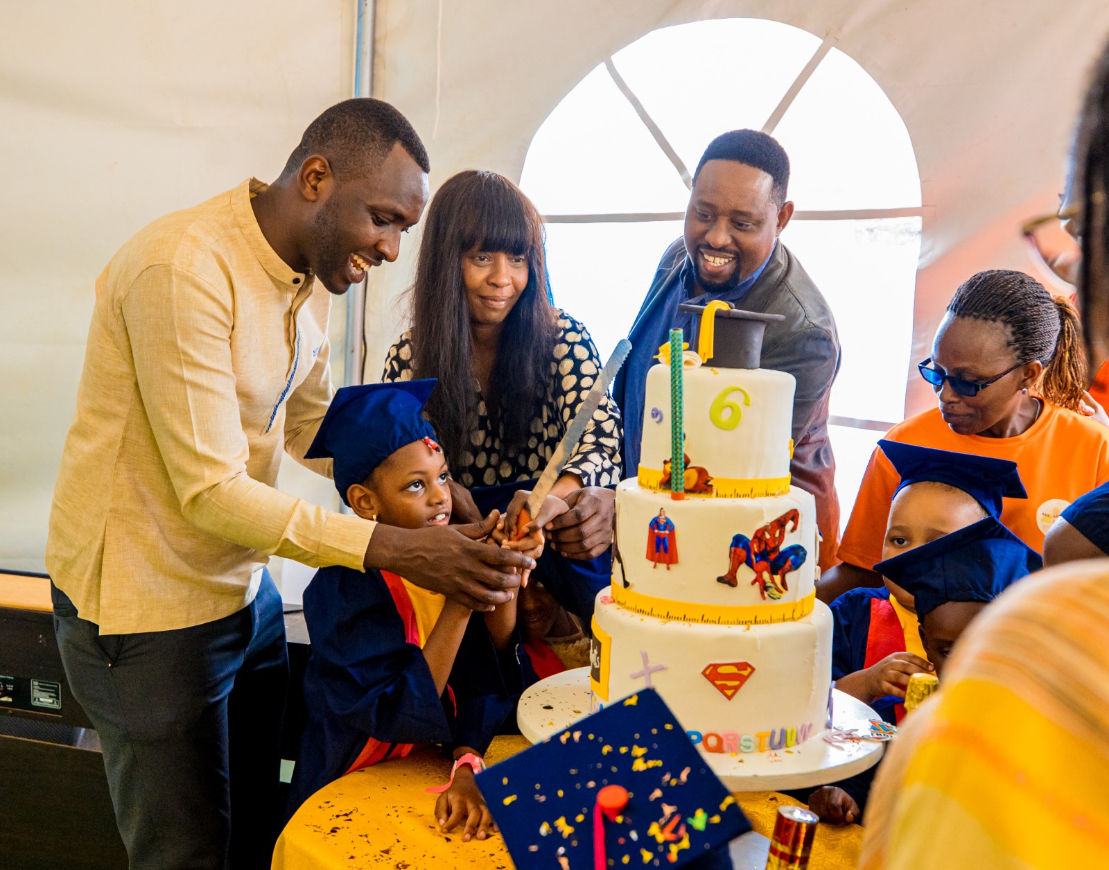 Children from Autism Rwanda Center cut a cake to celebrate their graduation.