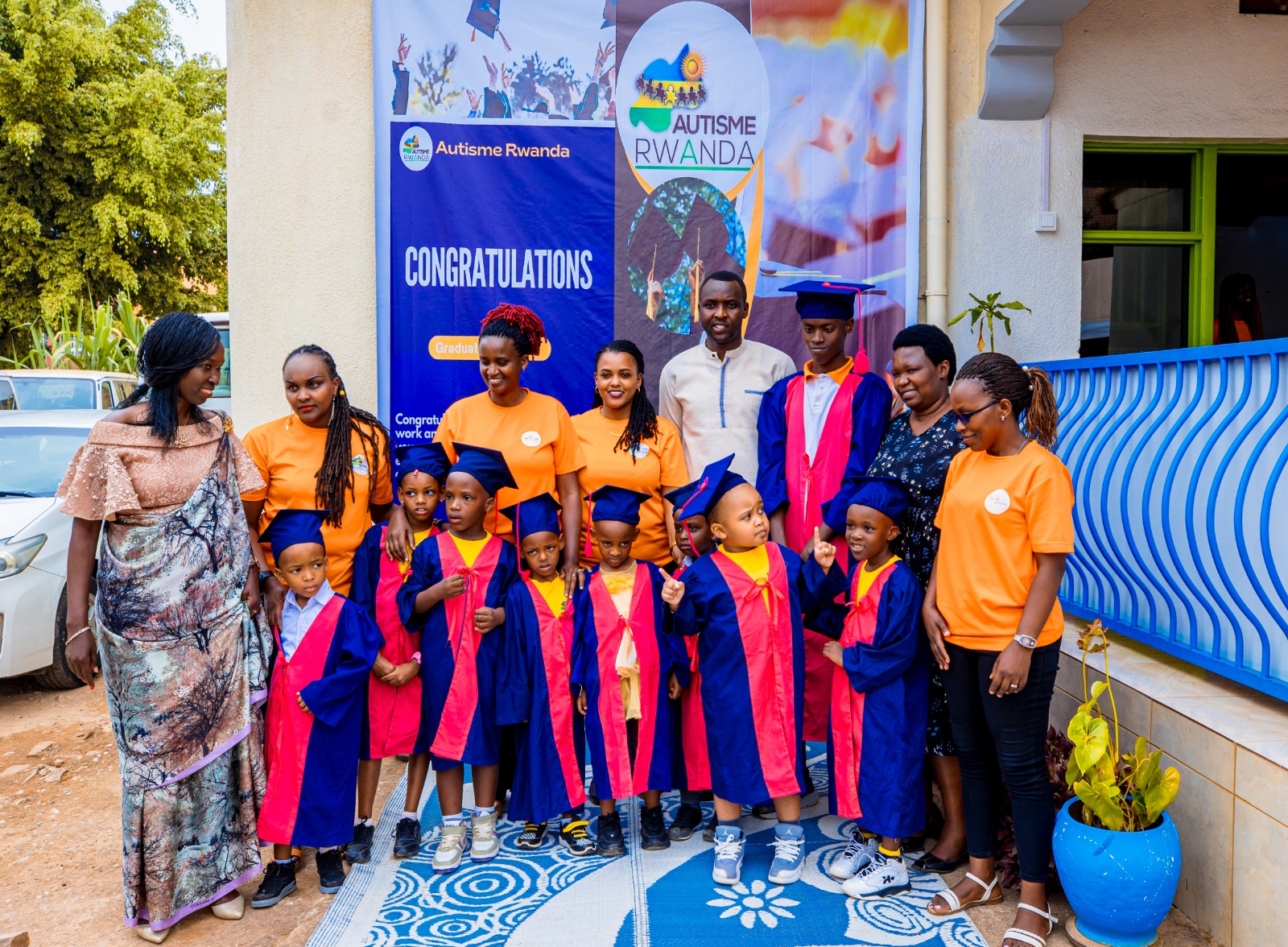 Children from Autism Rwanda Center pose for a photo with their parents and guardians after their graduation.