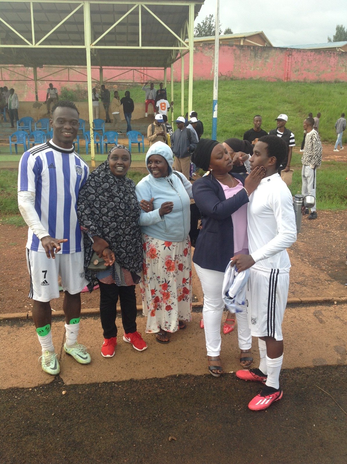 Festus Adejere (L) , a young Nigerian player who plays for Second Division side La Jeunesse FC, poses with fans after a game in which he scored the winning goal.