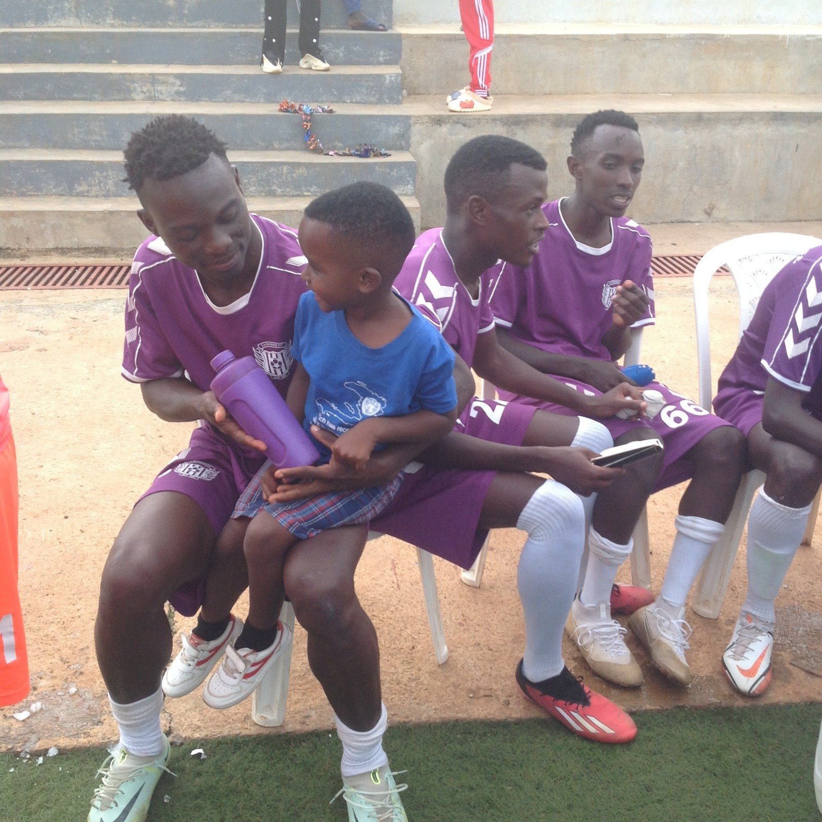 Adejere (carrying a young fan) says that the integration of foreign players into Rwandan teams has fostered a sense of unity and camaraderie.