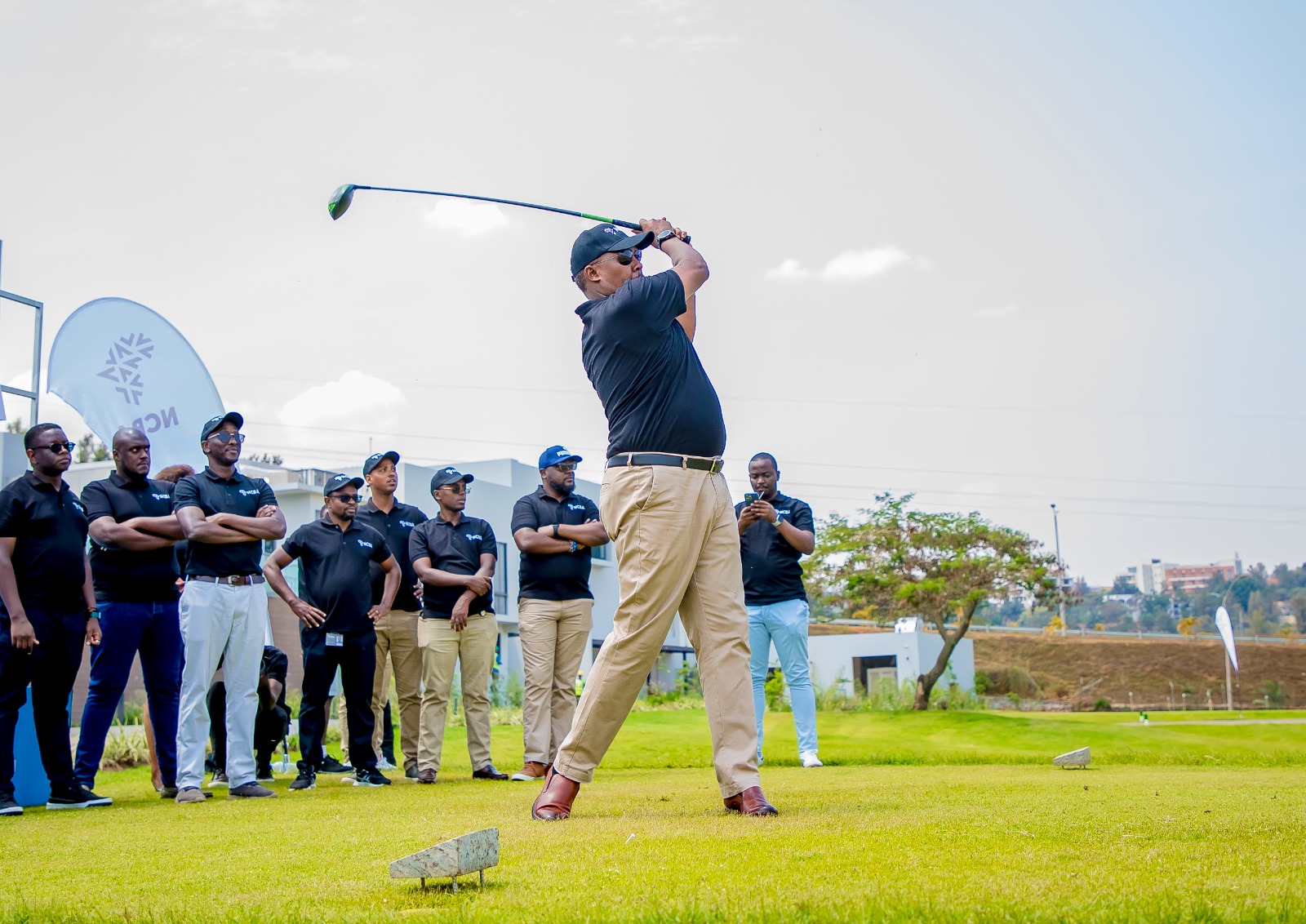 Andrew Kulayije, Captain of Kigali Golf Club executes a golf ball shot with a precise swing.