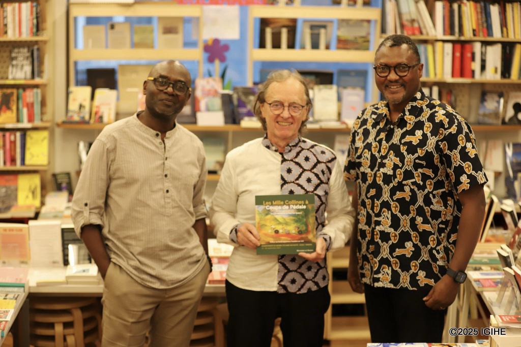 IGIHE journalist in a keepsake photo after an interview about the book "Les Mille Collines à Coups de Pédale," with Belgian painter Paul De Gobert and Rwandan writer Joseph Ndwaniye.