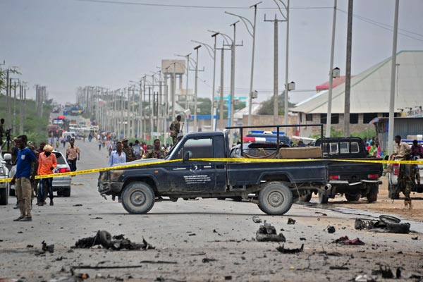 Somalian security forces and residents gather at the scene of a suicide car attack near the Defence Ministry in Mogadishu on April 9, 2017.
