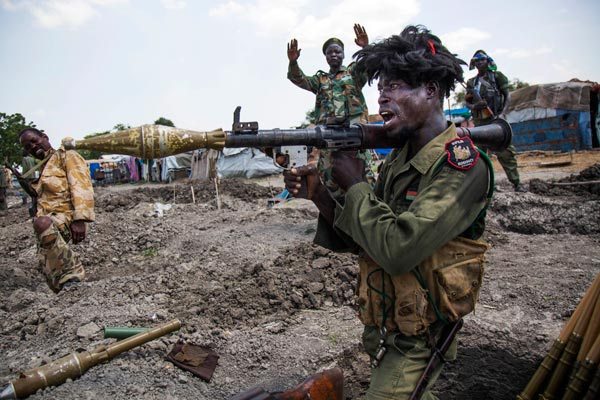 Soldiers of the Sudan People Liberation Army (SPLA) celebrate while standing in trenches in Lelo, outside Malakal, northern South Sudan, on October 16, 2016. Heavy fighting broke out on Ocotober 14 between SPLA (Government) and opposition forces in Wajwok and Lalo villages, outside Malakal.