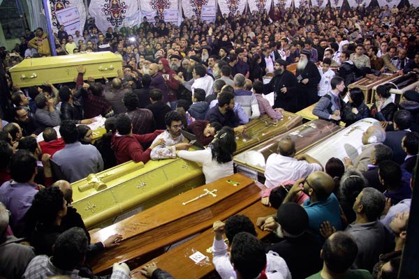 Egyptian Christians gather around and carry coffins during the late night funeral of the victims of a blast which killed worshippers attending Palm Sunday mass at the Mar Girgis Coptic Orthodox Church in the Nile Delta City of Tanta, 120 kilometres (75 miles) north of Cairo, on April 9, 2017.