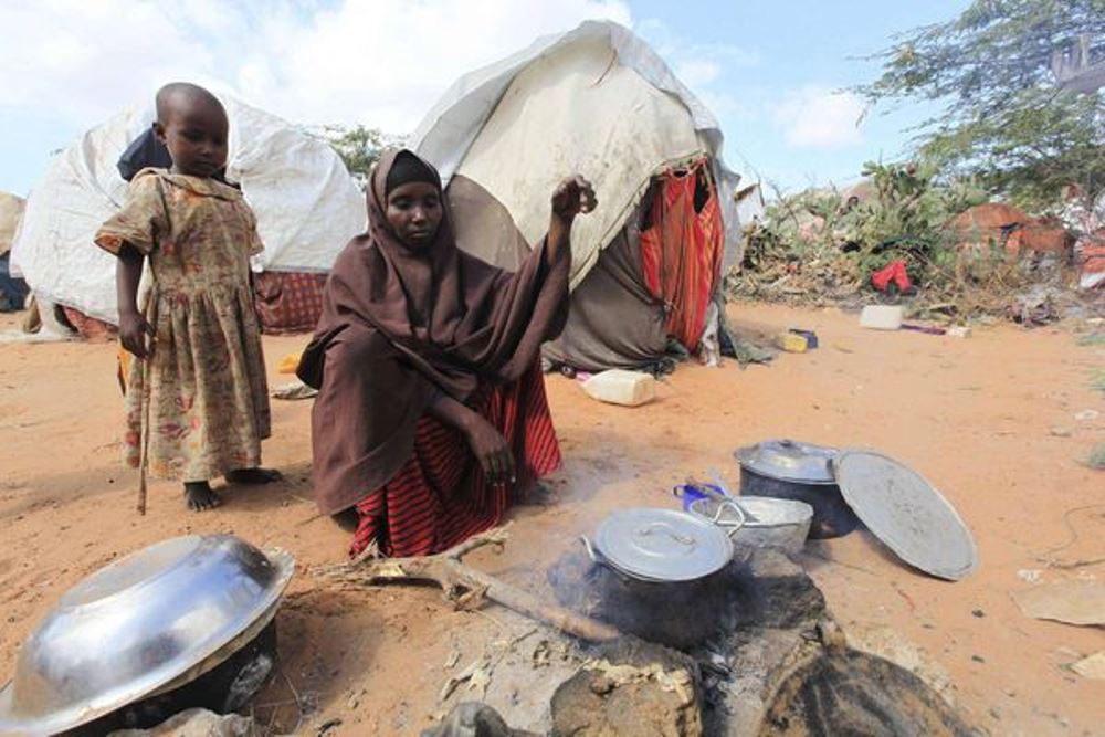 Kadija Mohamed cooks food for her children in a camp set up for internally displaced people in Dinsoor in southern Somalia, Jan. 5, 2012. FEISAL OMAR/REUTERS