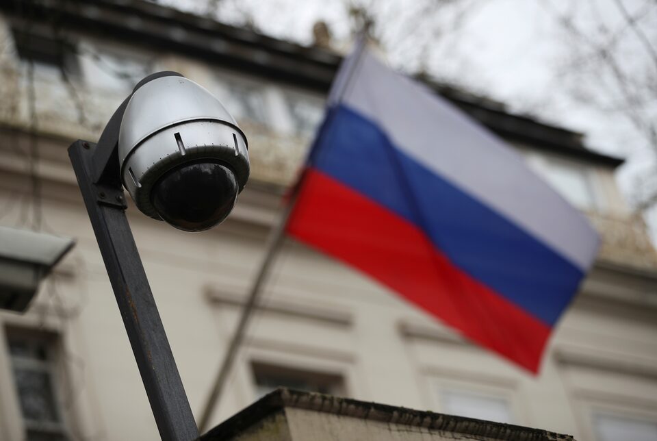 A security camera is seen, and a flag flies outside the consular section of Russia's embassy in London, Britain.