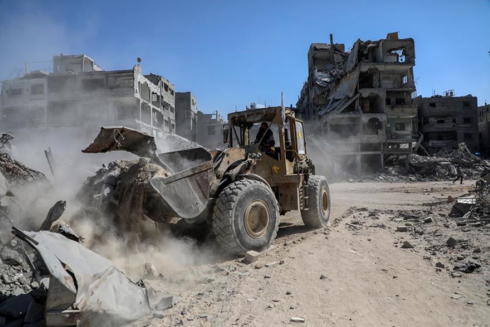 A heavy machinery removes debris from a street in Gaza City, on Oct. 19, 2025